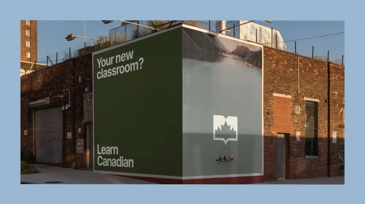 Макет кутового білборда Learn Canadian із написом «Your new classroom?», озером, каное та знаком із книгою й кленовим листком.