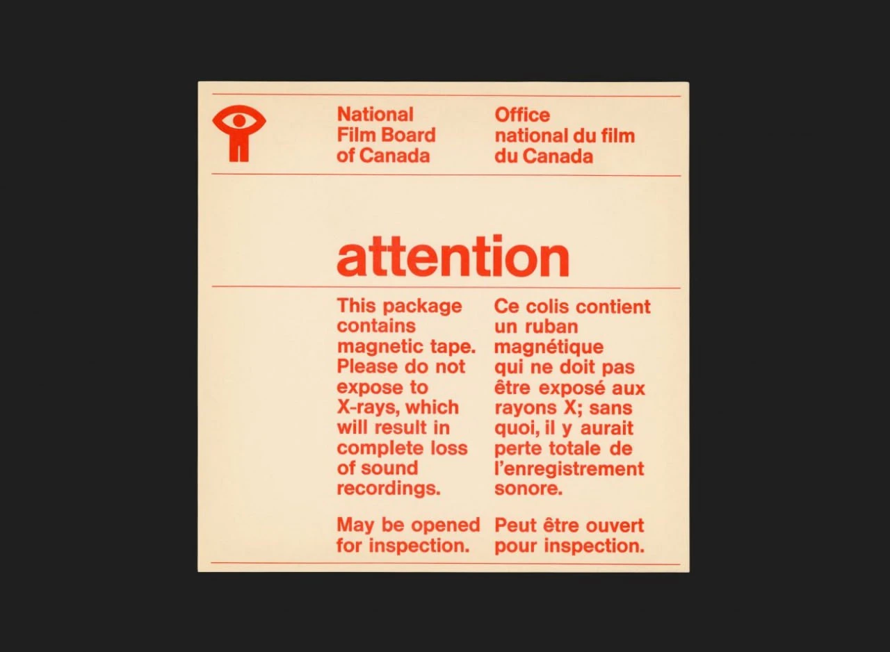 Bilingual red NFB label carrying a warning about magnetic tape